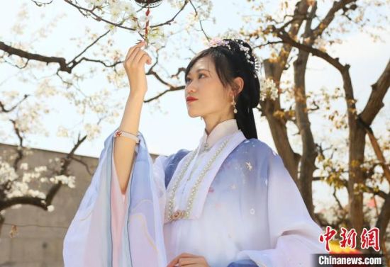 圖為蘭州青年身穿漢服在百年梨園賞景?！「哒?攝