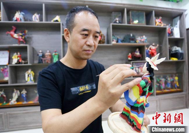 圖為安秋平正在創(chuàng)作代表隴南文縣民俗的《白馬人》作品?！「哒?攝