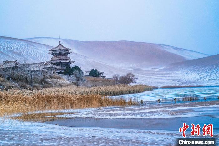 2021年11月28日，雪落鳴沙山月牙泉景區(qū)?！⊥醣筱y 攝