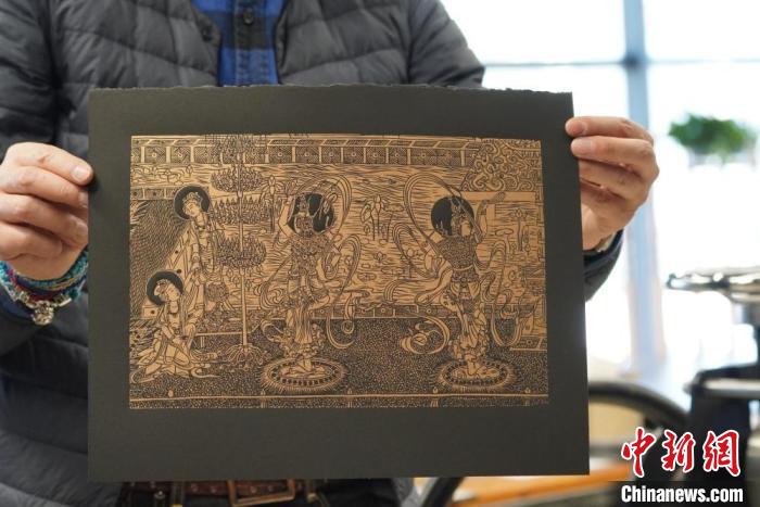 圖為手工書藝人展示敦煌雕版壁畫印刷品?！【琶赖┰?　攝