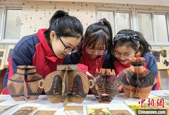 圖為學(xué)生用紙創(chuàng)作的立體彩陶?！⒂裉?攝