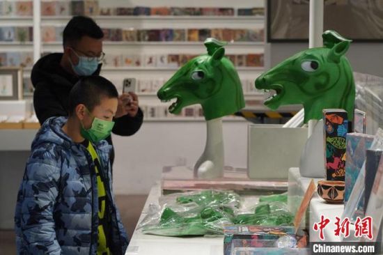 圖為“神馬來(lái)了”銅奔馬頭套吸引參觀者駐足。　九美旦增 攝
