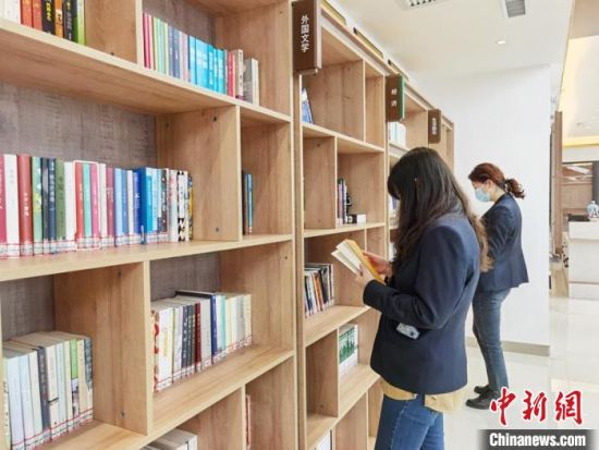 圖為在甘肅公航旅建設(shè)集團(tuán)有限公司的職工書屋，職工挑選書籍。　徐雪 攝