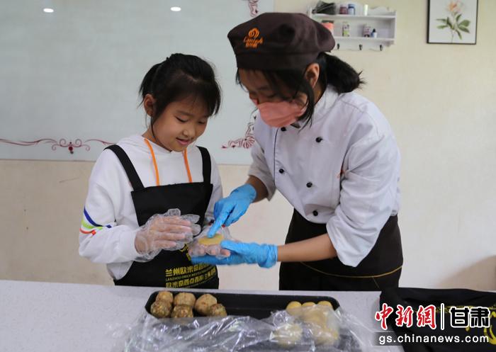 圖為在甘臺胞小朋友在工作人員指導(dǎo)下制作月餅。九美旦增 攝