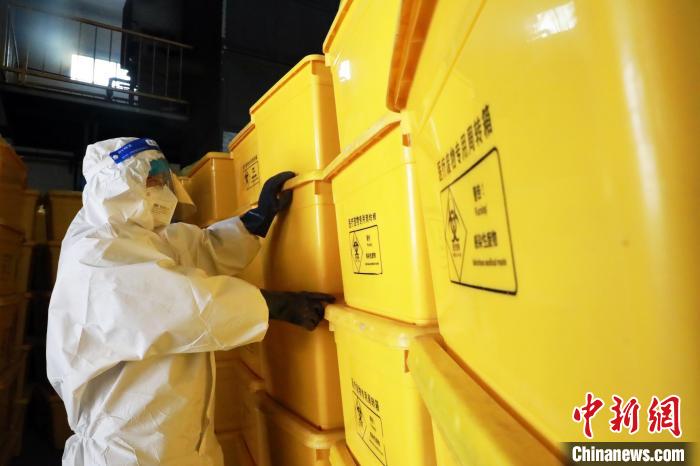 圖為工作人員搬運(yùn)醫(yī)療廢物專用周轉(zhuǎn)箱?！∥航ㄜ?攝