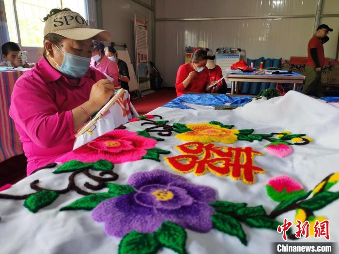 圖為婦女制作青繡?！?zhí)砀?攝