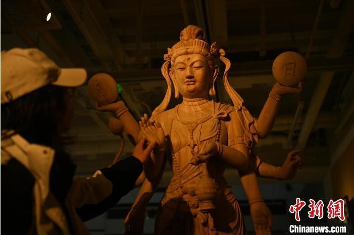 圖為季茂杰觀察自己創(chuàng)作的敦煌木雕。李亞龍 攝</p>
<p>