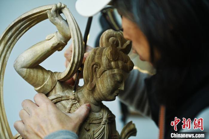 圖為季茂杰進(jìn)行敦煌元素的木雕創(chuàng)作。李亞龍 攝</p>
<p>