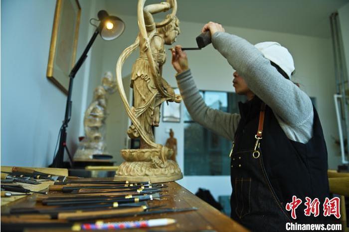 圖為季茂杰進(jìn)行敦煌元素的木雕創(chuàng)作。李亞龍 攝</p>
<p>