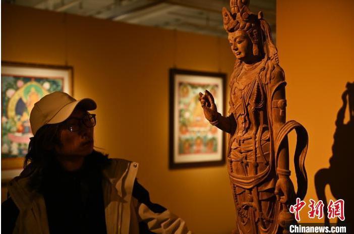 圖為季茂杰觀察自己創(chuàng)作的敦煌木雕。李亞龍 攝</p>
<p>