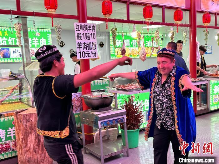 圖為餐飲經(jīng)營者在“西涼不夜城”跳起舞蹈引客。　戴文昌 攝</p><p>