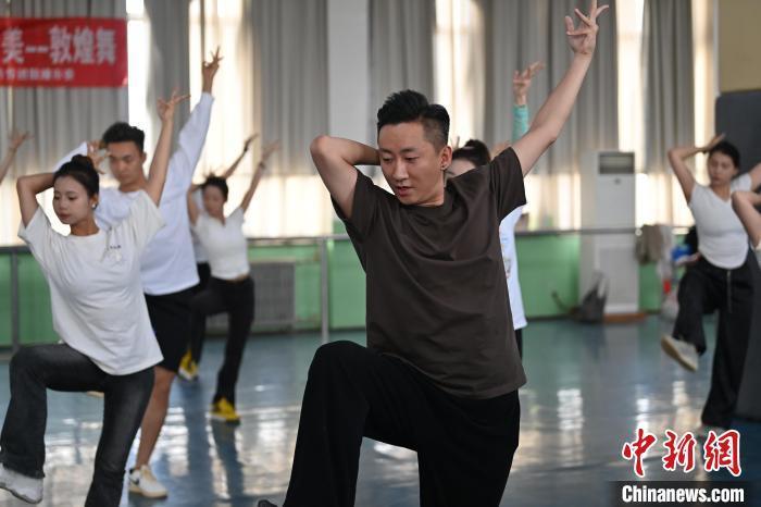 6月6日，在甘肅敦煌青年夜校課程中，青年學(xué)員學(xué)習(xí)敦煌舞課程。李亞龍 攝　　