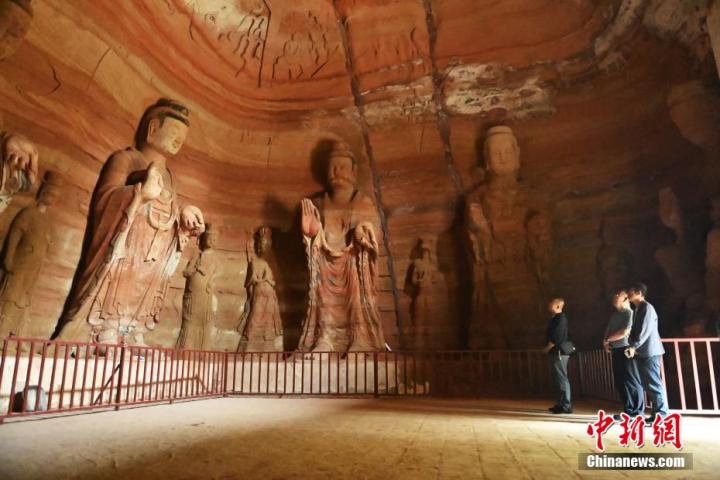 7月15日，游人參觀甘肅省平?jīng)鍪袥艽h百里石窟長(zhǎng)廊中的南石窟寺1號(hào)窟。百里石窟長(zhǎng)廊位于涇川縣境內(nèi)，由512個(gè)石窟、5眼窟中石井組成，現(xiàn)存王母宮石窟、鳳凰山石窟、南石窟寺、丈八寺石窟、羅漢洞石窟、太山寺石窟等規(guī)模較大的石窟群，還有數(shù)量眾多的小石窟群。南石窟寺開鑿于北魏永平三年，其中1號(hào)窟屬于大型七佛窟，七佛高達(dá)6米。中新社記者 李亞龍 攝