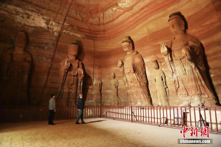 7月15日，游人參觀甘肅省平?jīng)鍪袥艽h百里石窟長(zhǎng)廊中的南石窟寺1號(hào)窟。百里石窟長(zhǎng)廊位于涇川縣境內(nèi)，由512個(gè)石窟、5眼窟中石井組成，現(xiàn)存王母宮石窟、鳳凰山石窟、南石窟寺、丈八寺石窟、羅漢洞石窟、太山寺石窟等規(guī)模較大的石窟群，還有數(shù)量眾多的小石窟群。南石窟寺開鑿于北魏永平三年，其中1號(hào)窟屬于大型七佛窟，七佛高達(dá)6米。中新社記者 李亞龍 攝