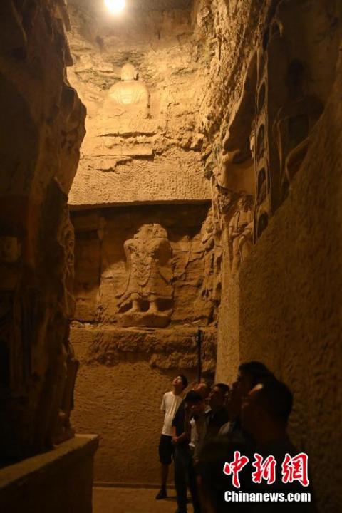 7月15日，游人參觀甘肅省平?jīng)鍪袥艽h百里石窟長(zhǎng)廊中的王母宮石窟。百里石窟長(zhǎng)廊位于涇川縣境內(nèi)，由512個(gè)石窟、5眼窟中石井組成，現(xiàn)存王母宮石窟、鳳凰山石窟、南石窟寺、丈八寺石窟、羅漢洞石窟、太山寺石窟等規(guī)模較大的石窟群，還有數(shù)量眾多的小石窟群。王母宮石窟又名千佛洞，該窟設(shè)計(jì)宏大，造像生動(dòng)，窟內(nèi)擁有造像數(shù)百尊，是較為珍貴的佛教文化遺存。中新社記者 李亞龍 攝</p>
<p>