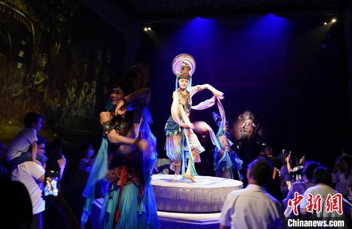 《樂動敦煌》是全球首部洞窟式沉浸體驗劇，利用真人與數(shù)字影像虛實交換實現(xiàn)沉浸式體驗。圖為2023年8月28日晚，《樂動敦煌》演出。(資料圖)中新社記者 毛建軍 攝